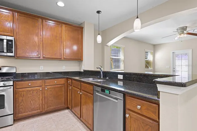 a kitchen with granite countertop cabinets stainless steel appliances and a sink