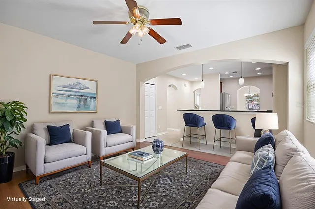 an empty room with wooden floor and a ceiling fan
