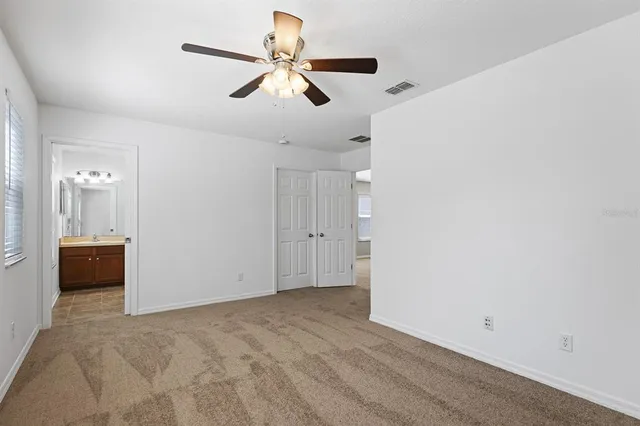 an empty room with a window and a fan