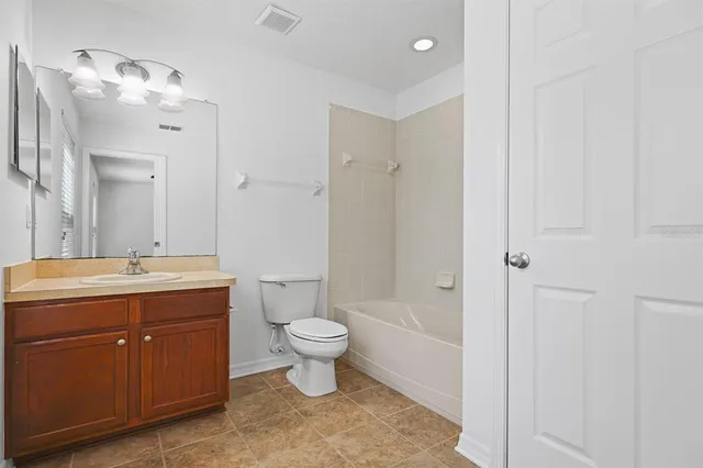an empty room with closet and a chandelier fan