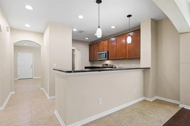 a kitchen with granite countertop a sink a counter space appliances and cabinets