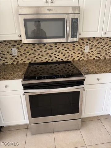 a stove top oven sitting inside of a kitchen