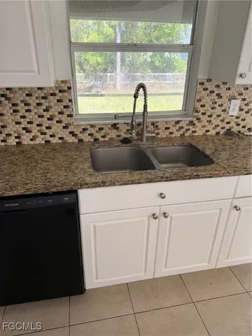 a kitchen with granite countertop a sink and a stove