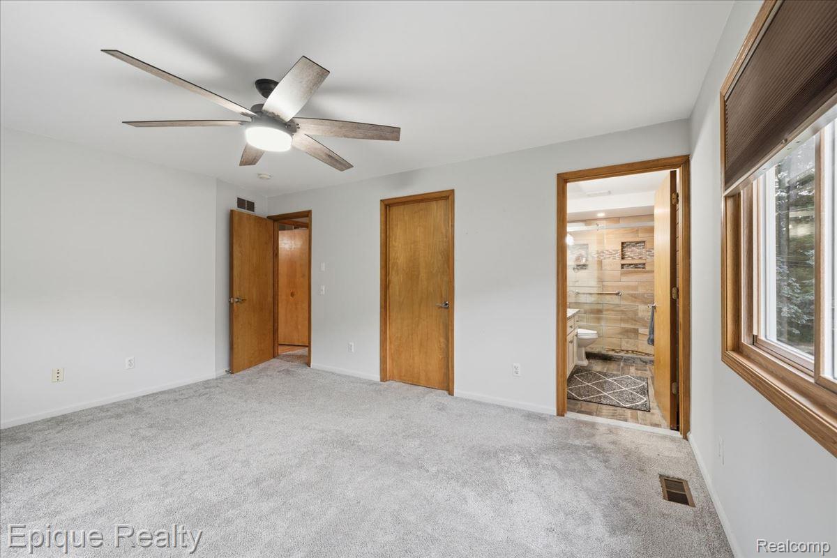 1221 Rhodes Road Lake Orion, MI 48360 - Photo 33 of 72 Carpeted room featuring a ceiling fan with integrated lighting, a large window with blinds, and light-toned walls