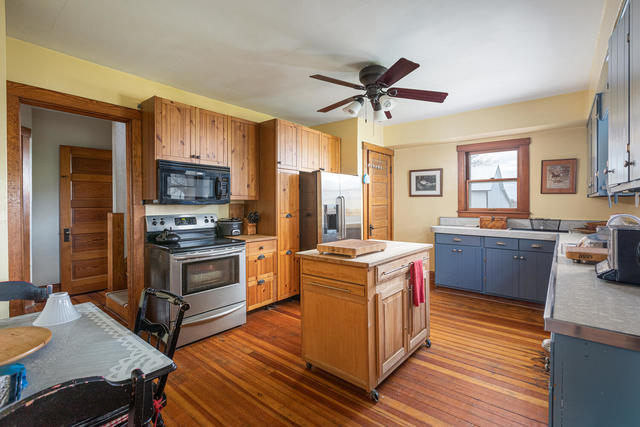 1111 Simons Road Oswego, IL 60543 - Photo 11 of 37 a kitchen with stainless steel appliances a stove a sink dishwasher a refrigerator and a dining table with wooden floor