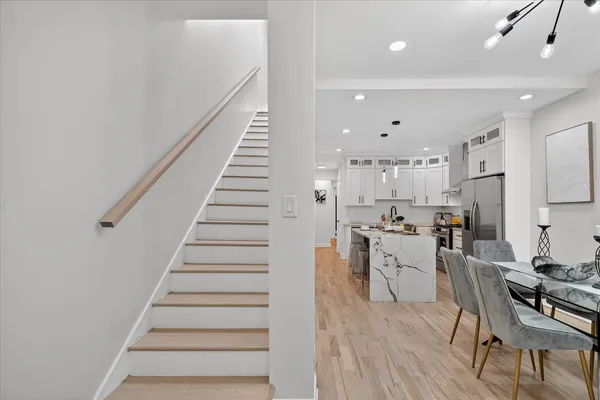 a kitchen with stainless steel appliances white cabinets and wooden floor