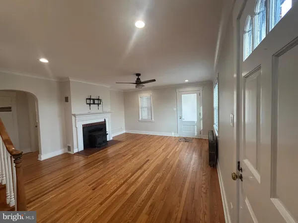 a view of empty room with wooden floor and fireplace