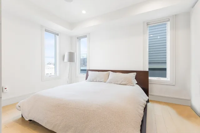 a large bed sitting in a bedroom next to a window