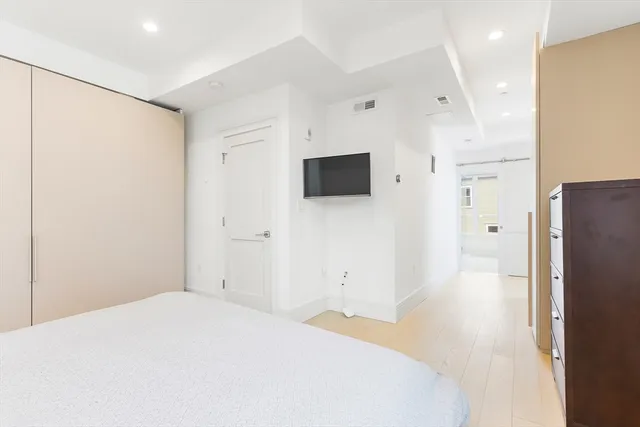 a bedroom with a bed and a flat screen tv