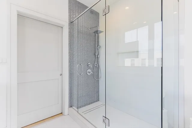 a bathroom with a shower and a glass door