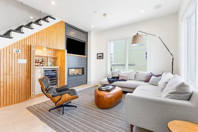 a living room with furniture a flat screen tv and a large window