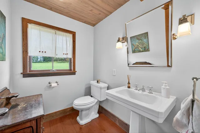 a bathroom with a toilet a sink and a mirror