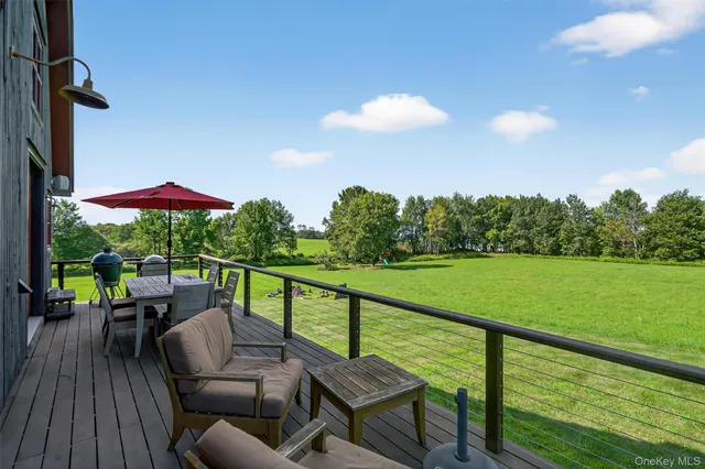 a view of a deck with couches table and chairs with wooden floor