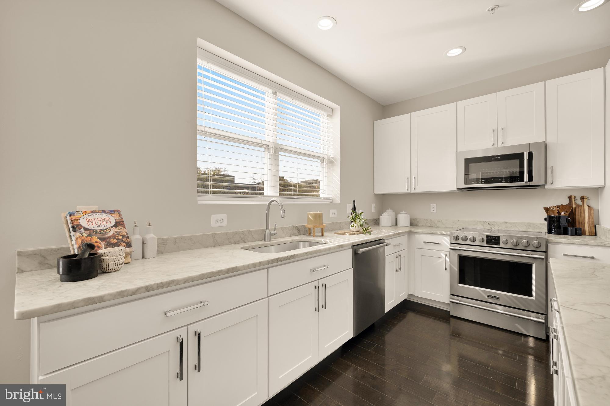 3302 9th Street Northeast, Unit 2 Washington, DC 20017 - Photo 10 of 40 a kitchen with stainless steel appliances granite countertop white cabinets a sink and a window