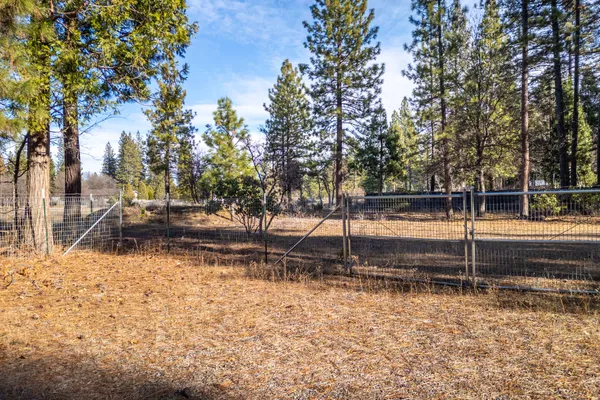 a view of a yard with wooden fence