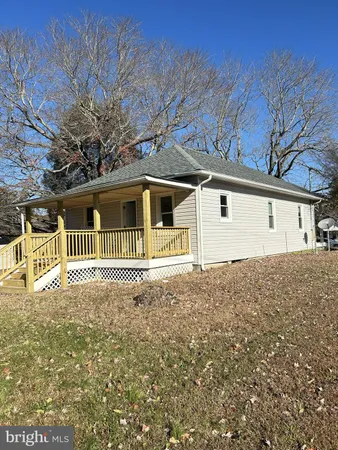 a front view of a house with a large tree