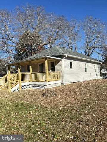 a front view of a house with a large tree