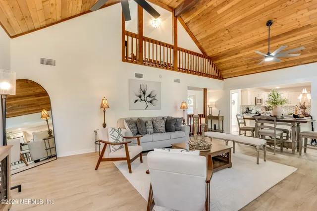a living room with furniture and floor to ceiling windows