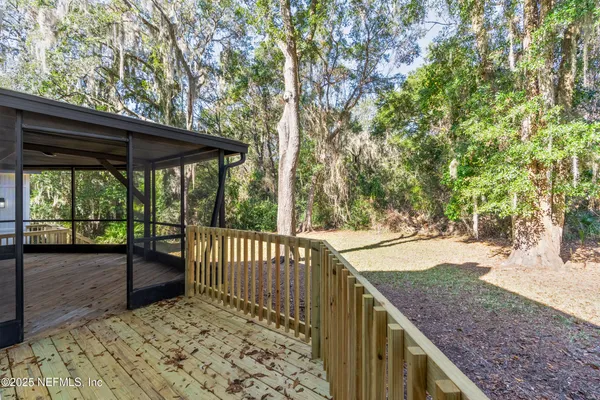 a view of a backyard with wooden fence and floor