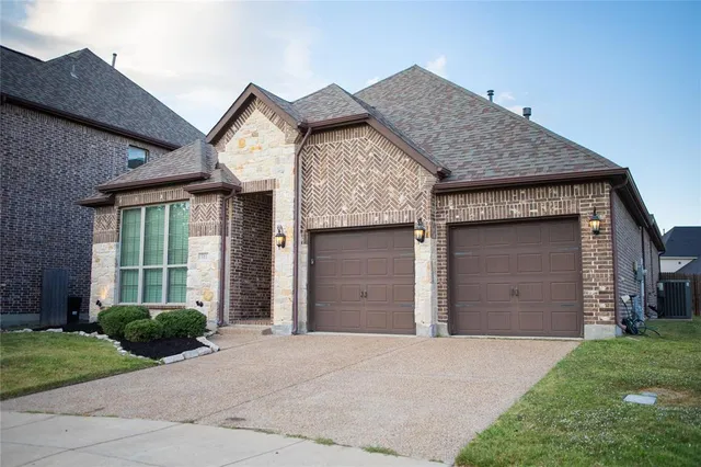 front view of a house with a yard and garage