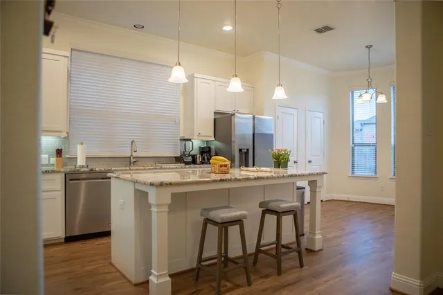 a kitchen with a table chairs sink and wooden floor
