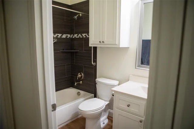 a bathroom with a granite countertop toilet and a sink