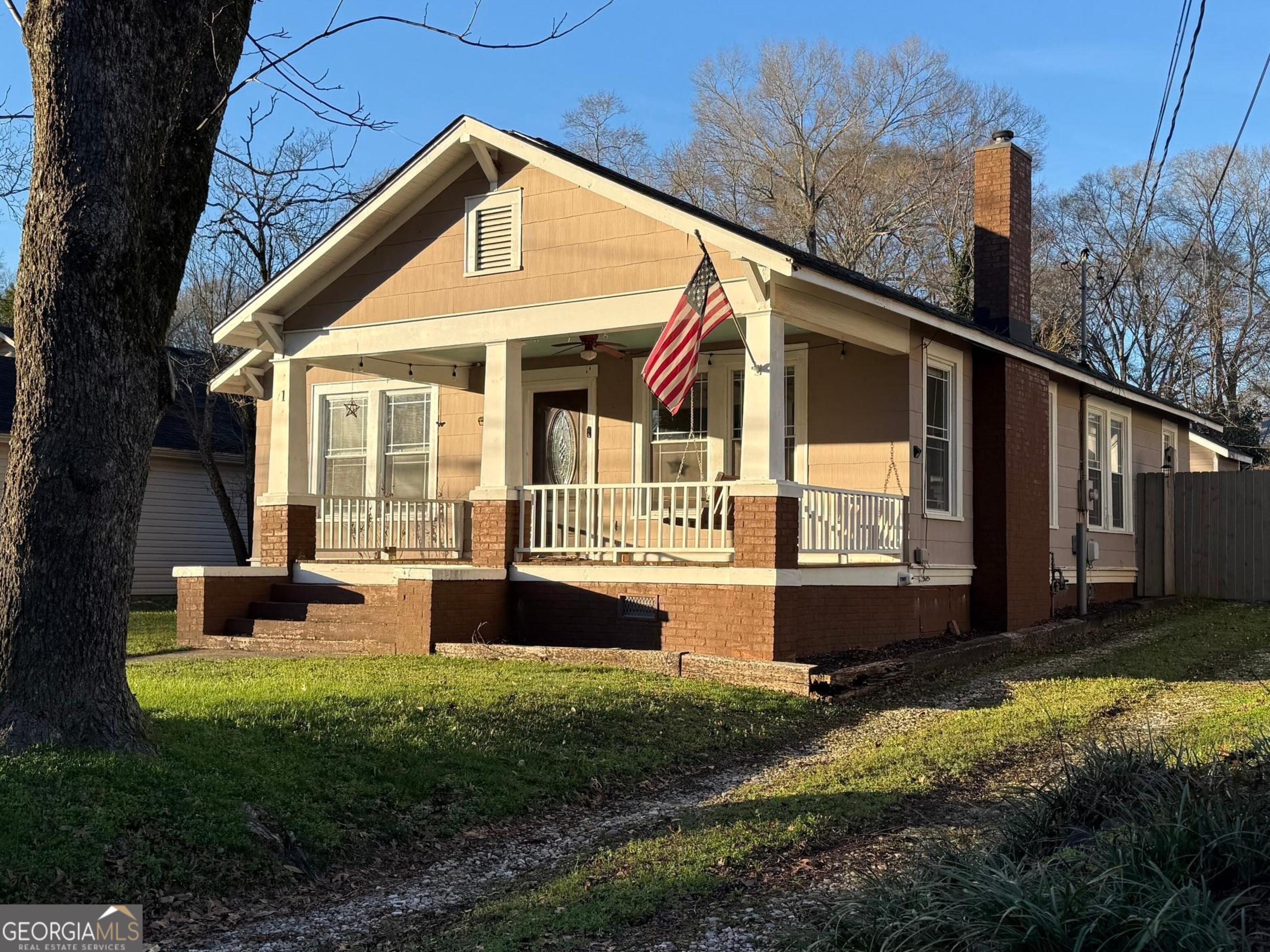 71 Clark Street Newnan, GA 30263 - Photo 2 of 19 a front view of a house with a yard table and chairs