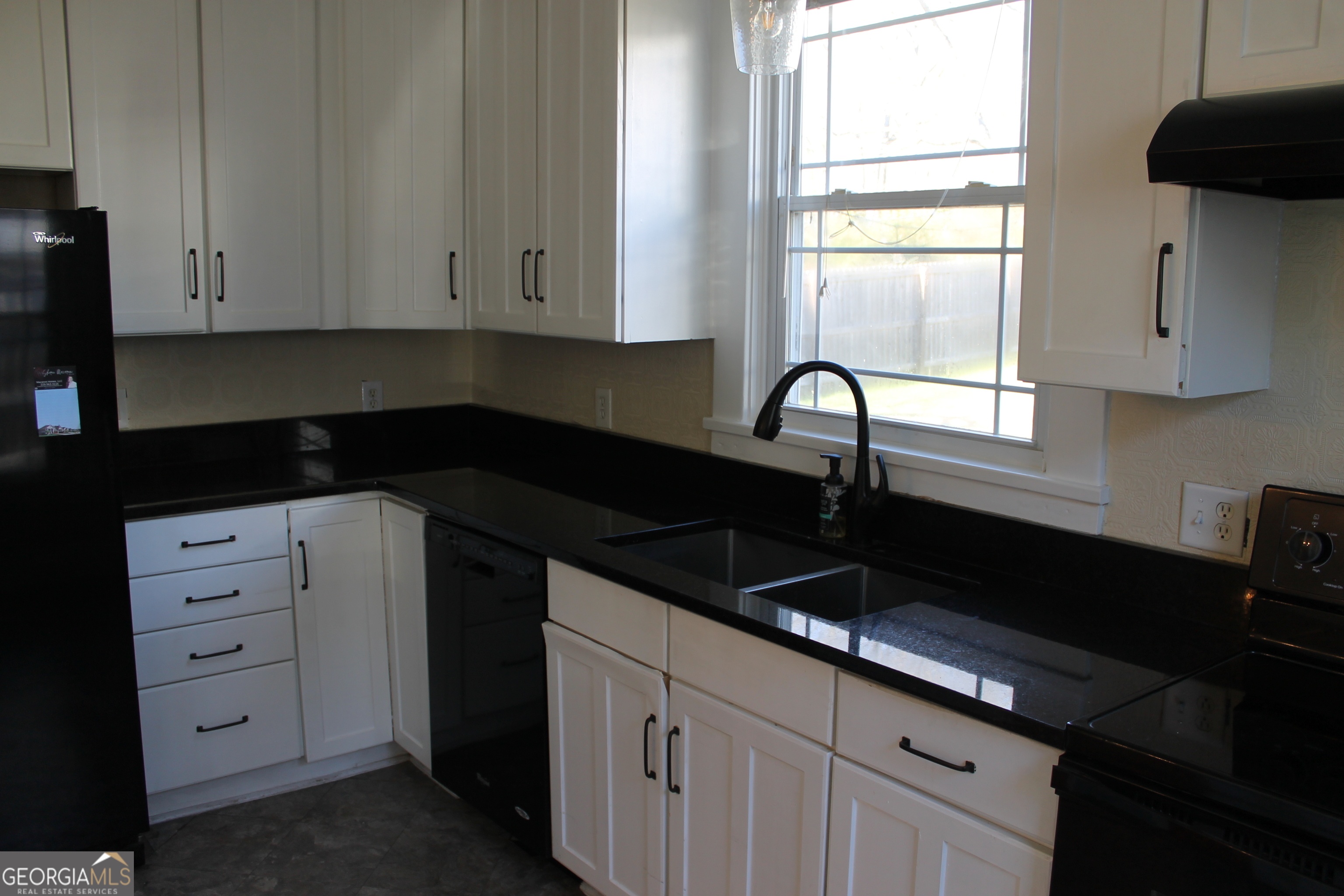 71 Clark Street Newnan, GA 30263 - Photo 6 of 19 a kitchen with granite countertop white cabinets sink and window