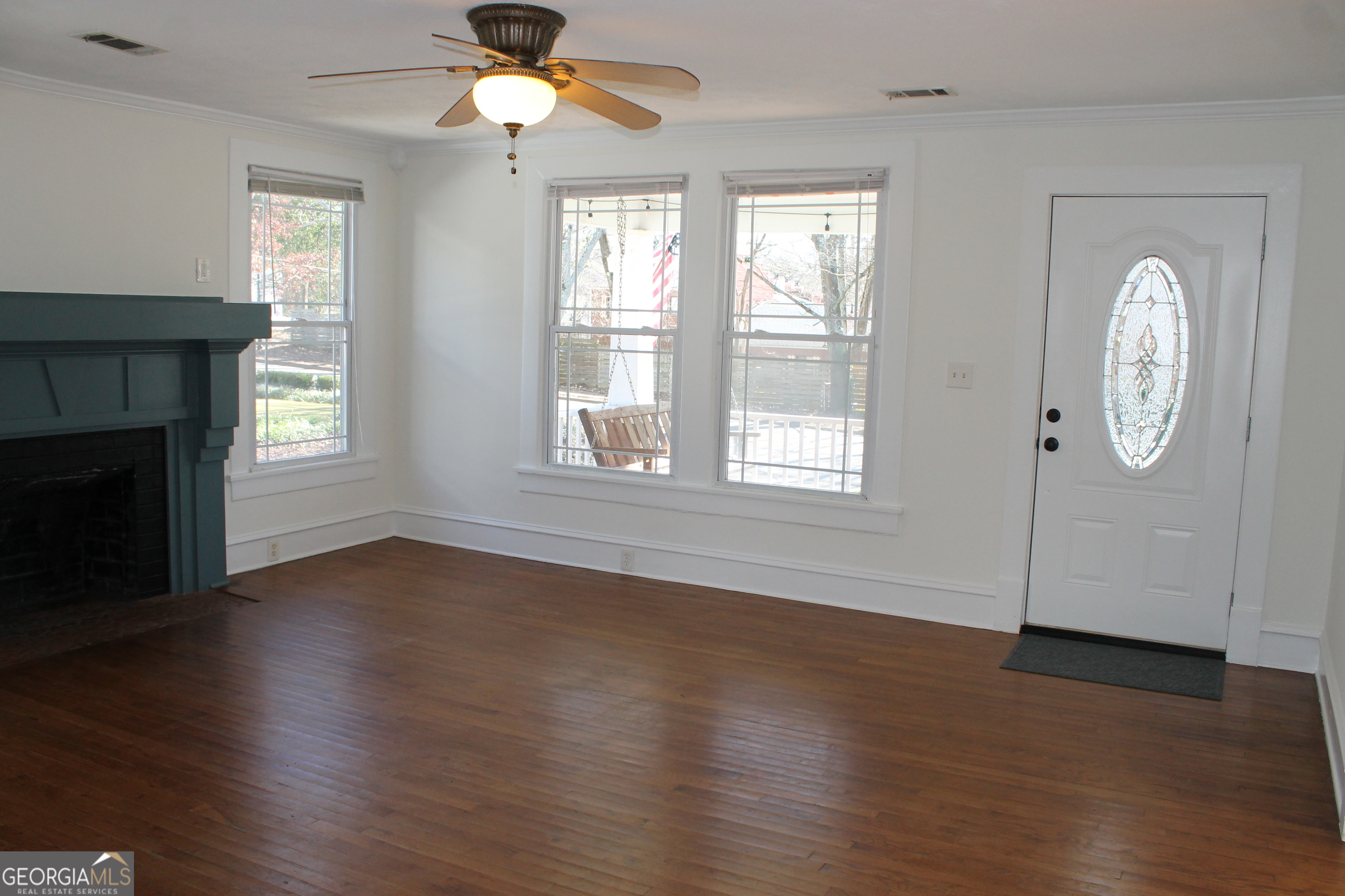 71 Clark Street Newnan, GA 30263 - Photo 8 of 19 an empty room with wooden floor fireplace and windows
