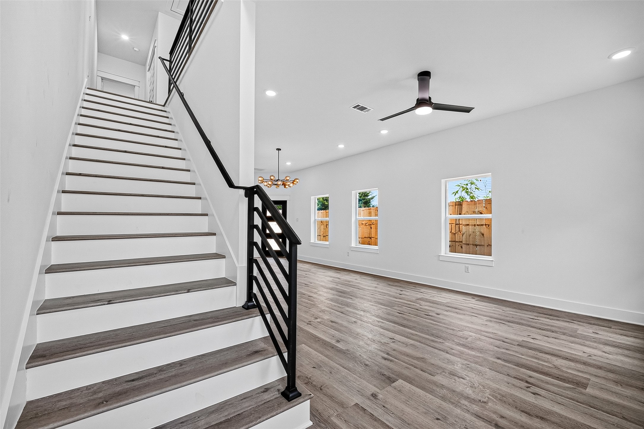 6747 Liverpool Street Houston, TX 77021 - Photo 18 of 38 A contemporary staircase with white risers and wood-grain treads serves as a functional centerpiece in the sunny, open first-floor layout.