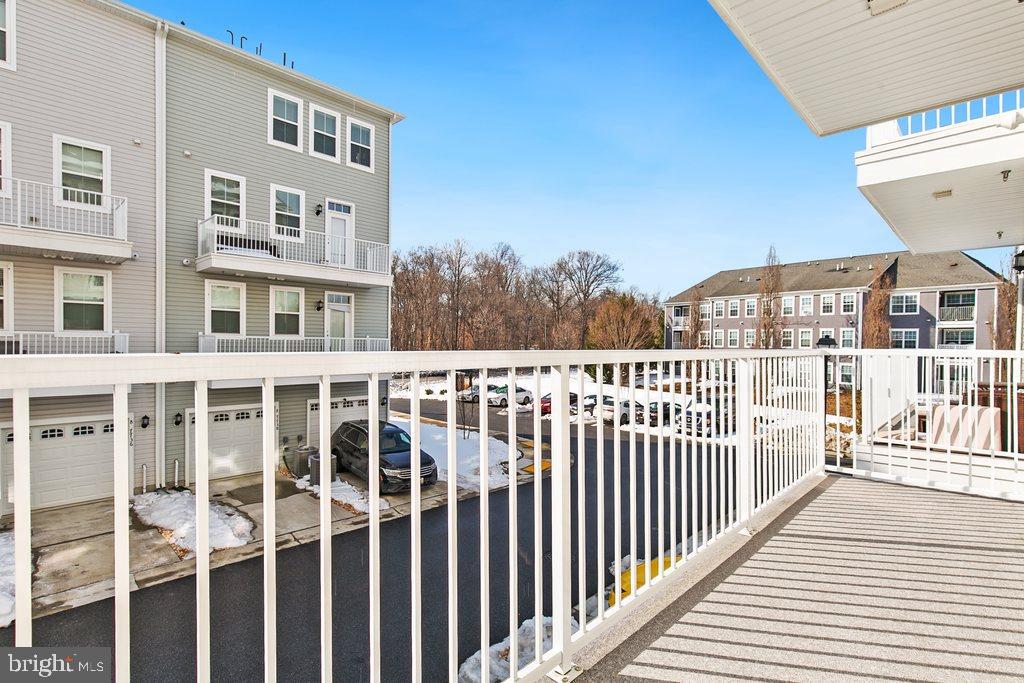 7203 Gringotts Way, Unit A Elkridge, MD 21075 - Photo 19 of 23 a view of a balcony with wooden floor and fence