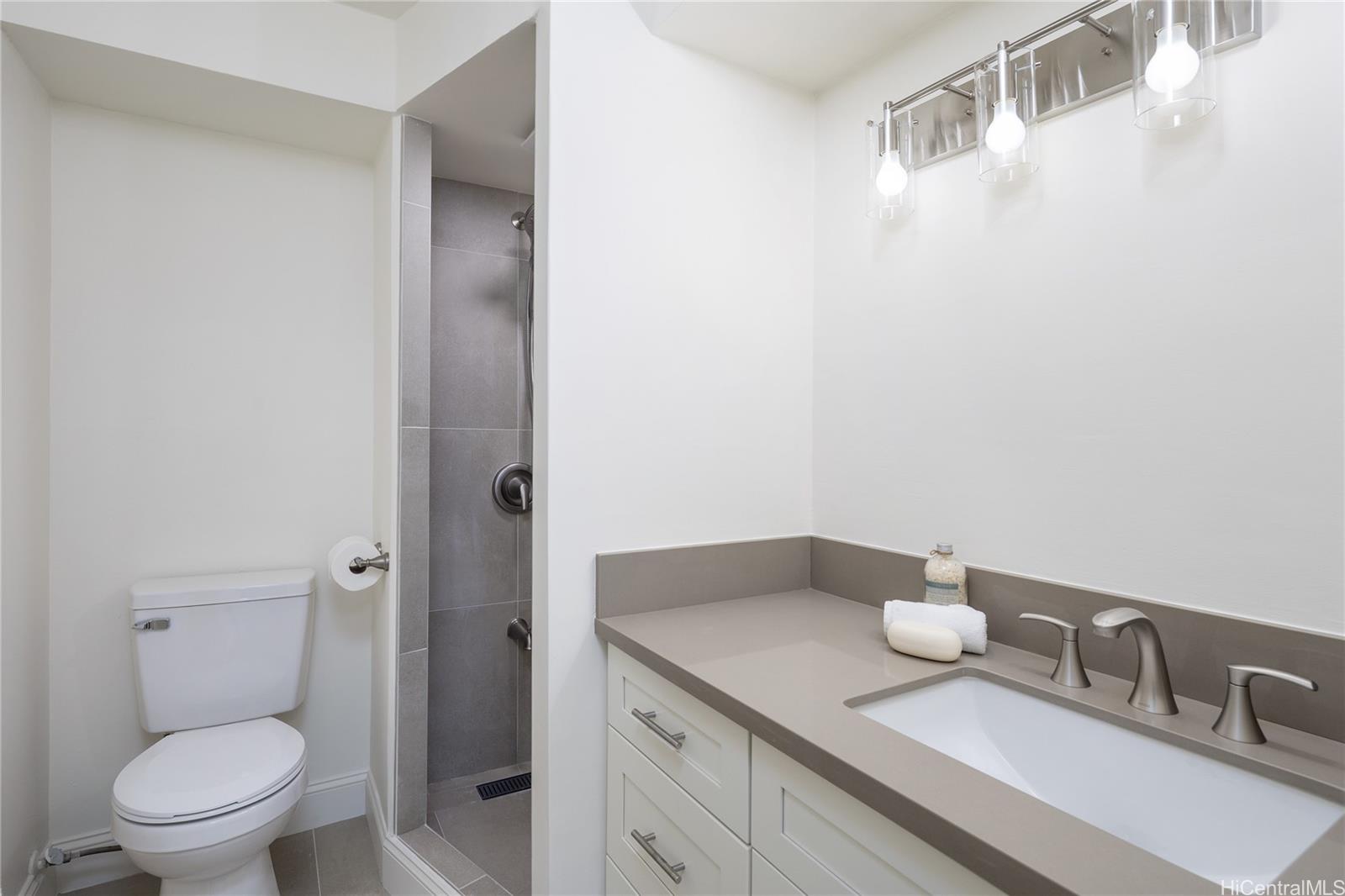 1700 Ala Moana Boulevard, Unit 3104 Honolulu, HI 96815 - Photo 8 of 15 a bathroom with a granite countertop sink and a toilet