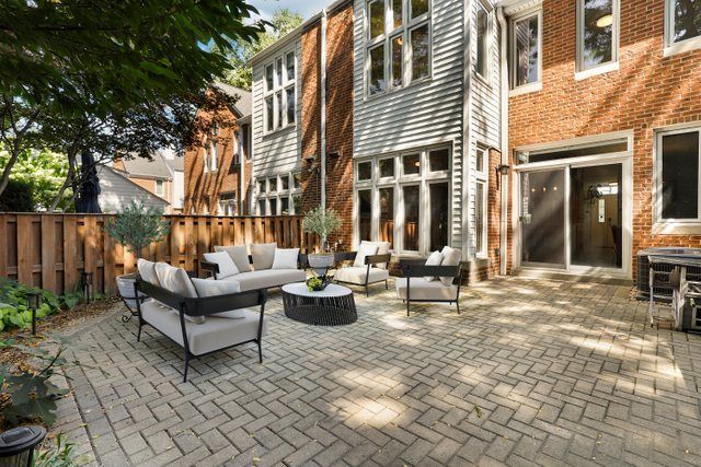 a view of a patio with couches table and chairs and potted plants