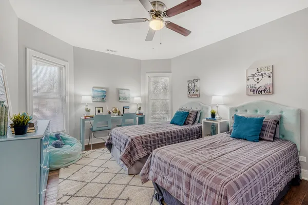 a bedroom with two beds and a potted plant