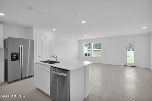 a kitchen with stainless steel appliances granite countertop a sink a refrigerator and a stove