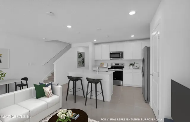 a living room with stainless steel appliances furniture and a view of kitchen