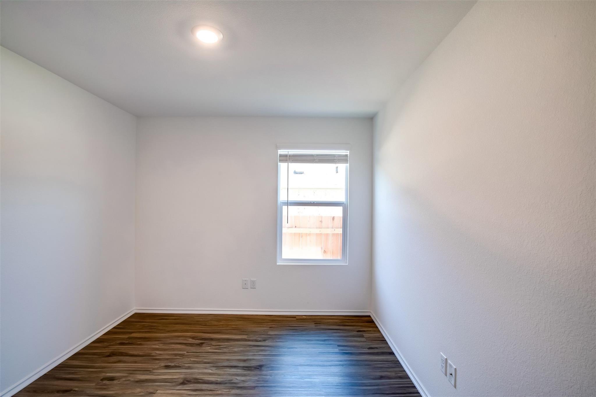 614 Milliner Loop Hutto, TX 78634 - Photo 8 of 25 A well-lit, neutral interior space offering versatility and natural light through its window.