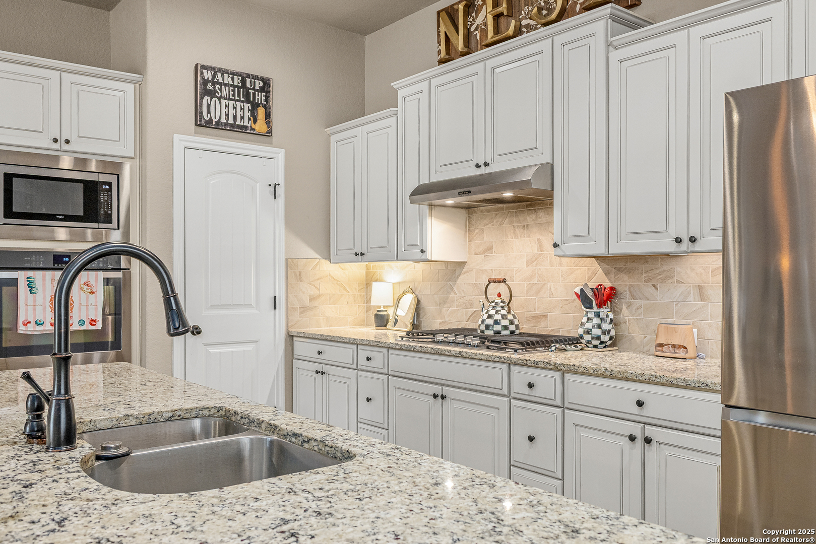 28938 Fairs Gate Fair Oaks Ranch, TX 78015 - Photo 6 of 41 a kitchen with stainless steel appliances granite countertop a sink a stove and white cabinets