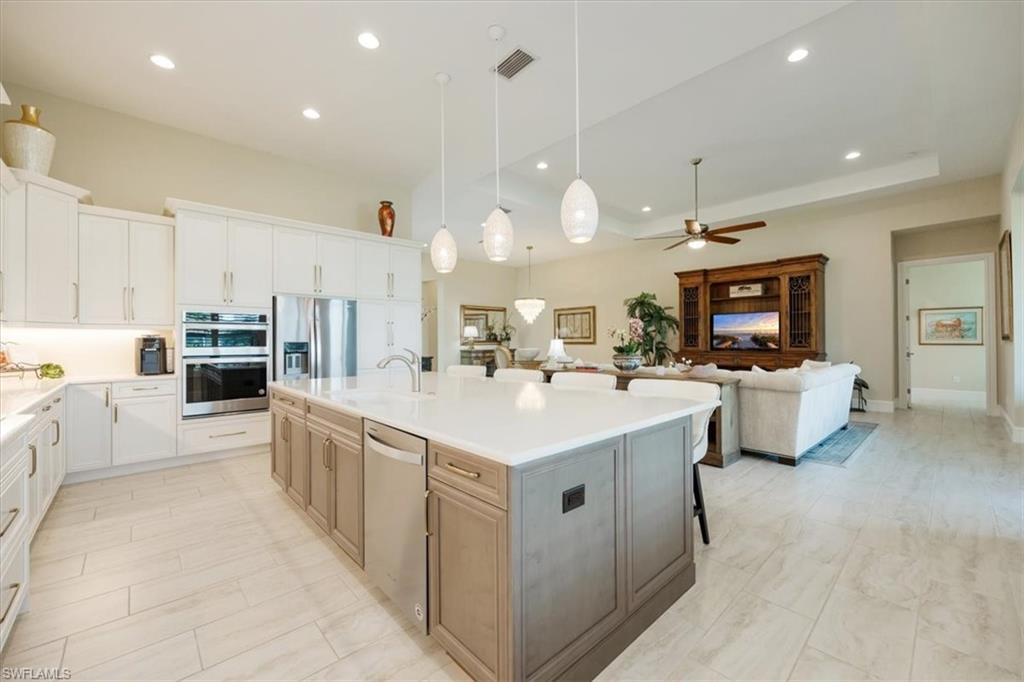 6152 Rodney Bay Lane Naples, FL 34113 - Photo 11 of 45 a large white kitchen with a white countertops a stove a sink and a refrigerator