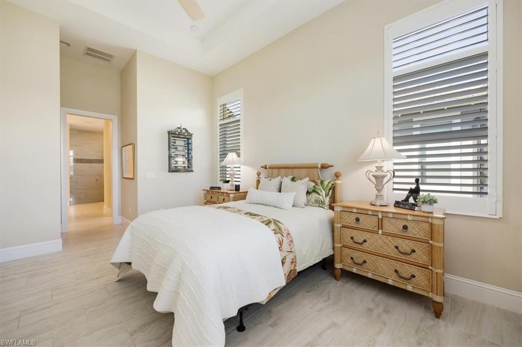 6152 Rodney Bay Lane Naples, FL 34113 - Photo 18 of 45 a bedroom with a bed and a dresser