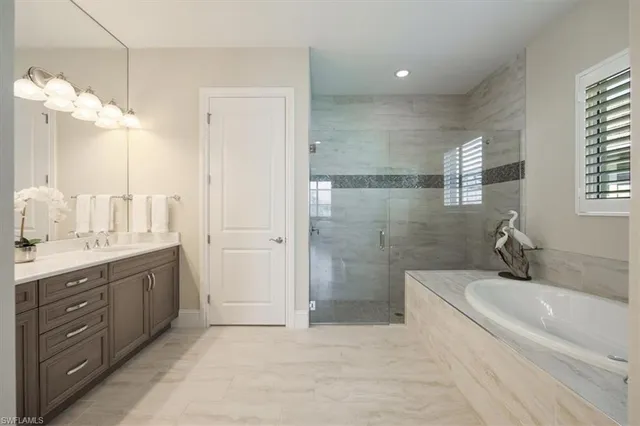 a spacious bathroom with a granite countertop sink a toilet a mirror and shower