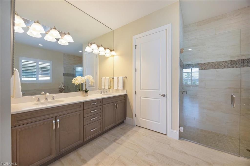 6152 Rodney Bay Lane Naples, FL 34113 - Photo 20 of 45 a spacious bathroom with a double vanity sink mirror and shower