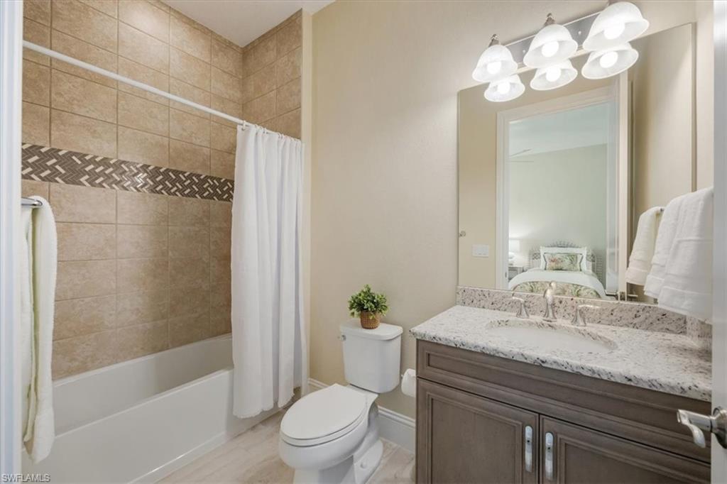 6152 Rodney Bay Lane Naples, FL 34113 - Photo 23 of 45 a bathroom with a granite countertop sink a toilet and shower
