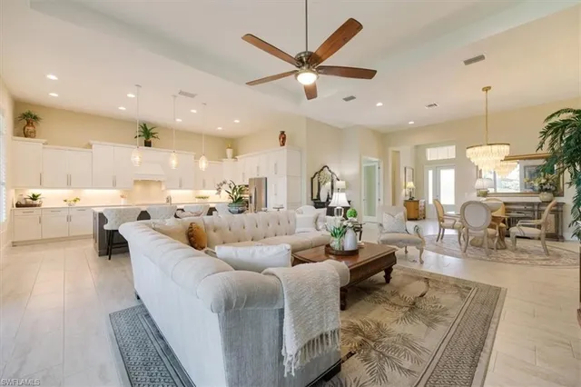 a living room with couches and kitchen view with wooden floor