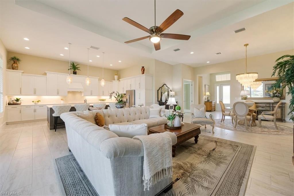6152 Rodney Bay Lane Naples, FL 34113 - Photo 5 of 45 a living room with couches and kitchen view with wooden floor