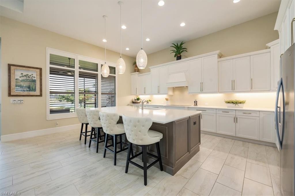 6152 Rodney Bay Lane Naples, FL 34113 - Photo 6 of 45 a kitchen with a table chairs sink and cabinets