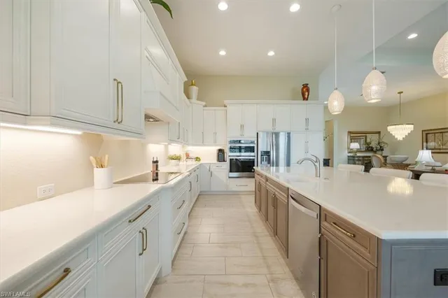 a large kitchen with stainless steel appliances lots of counter space and a sink