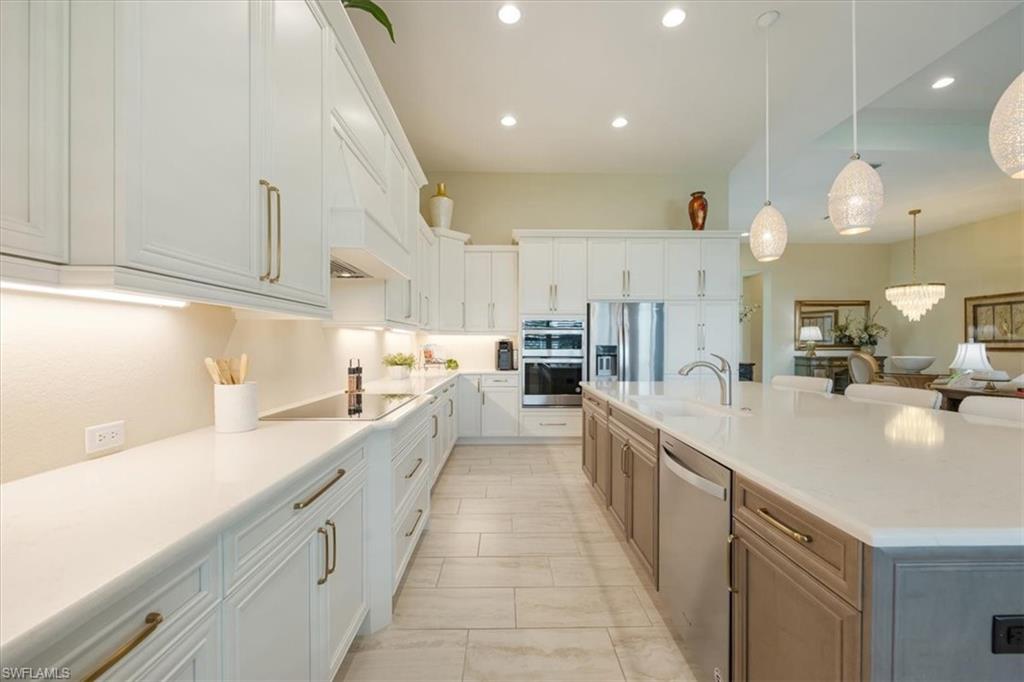 6152 Rodney Bay Lane Naples, FL 34113 - Photo 7 of 45 a large kitchen with stainless steel appliances lots of counter space and a sink