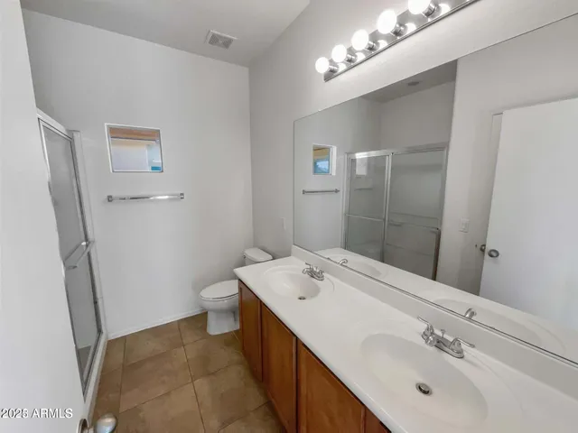 a bathroom with a double vanity sink mirror and toilet