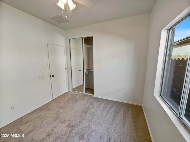 a view of a room with wooden floor and a ceiling fan